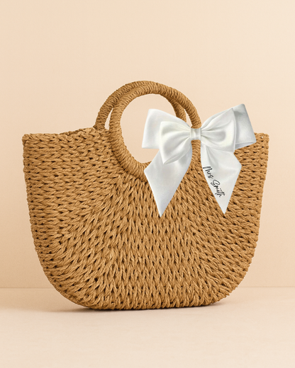 Woven handbag with a white bow on a beige background